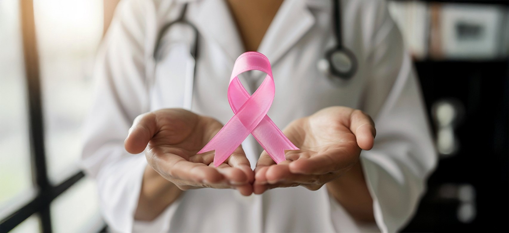 Doctor holding pink ribbon for breast cancer awareness at Rainbow Children’s Hospital