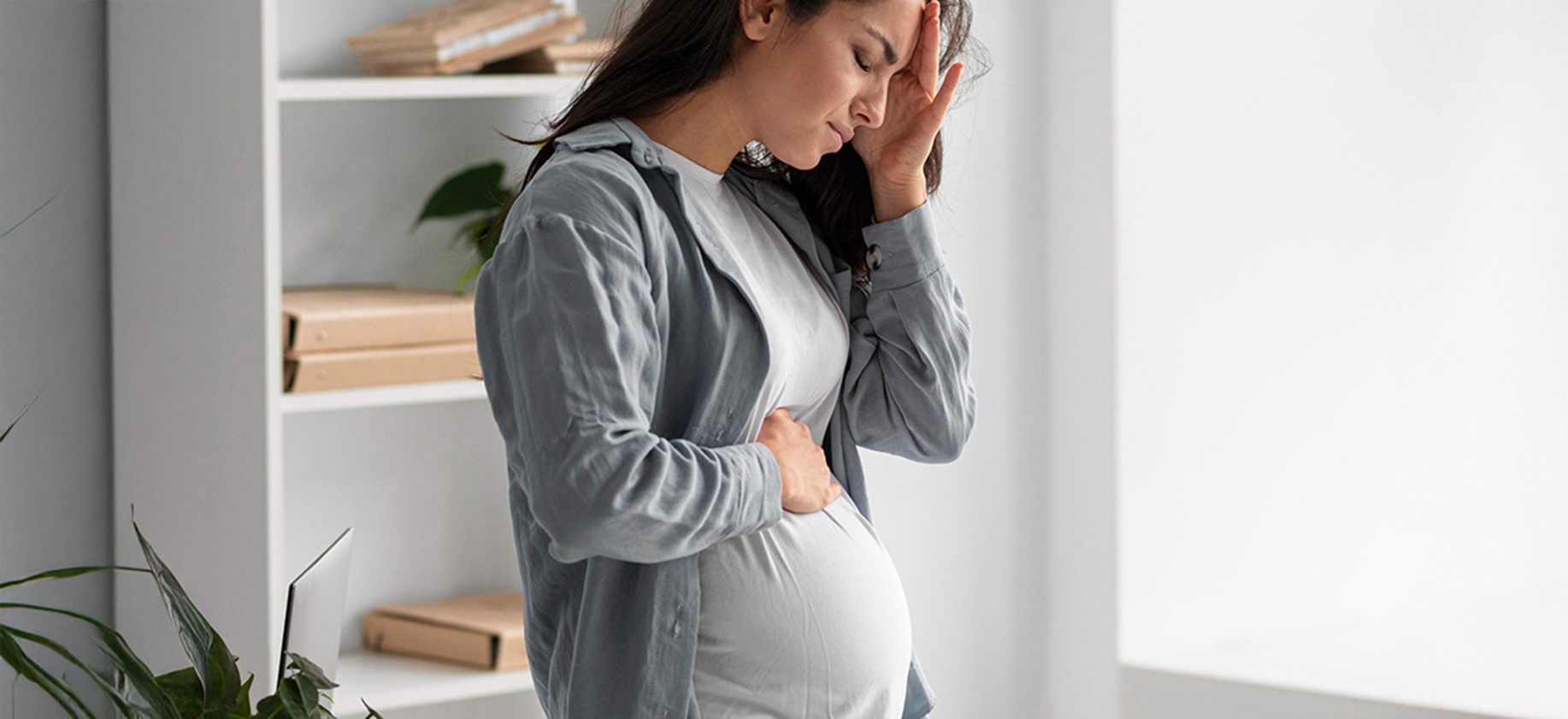 Pregnant woman experiencing discomfort, indicating high-risk pregnancy, at BirthRight by Rainbow Hospitals