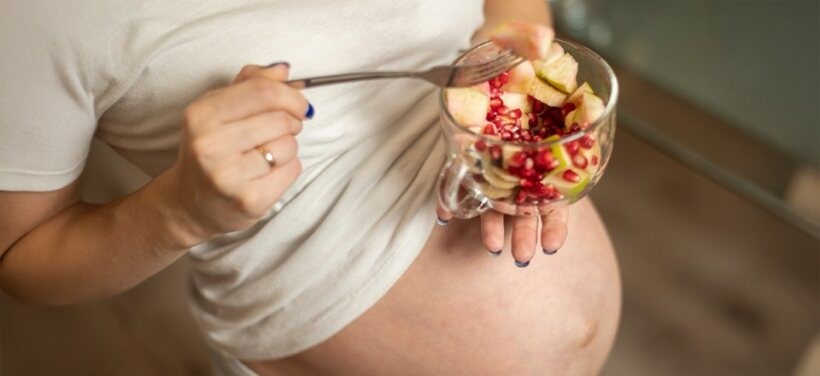 Pregnant woman holding a bowl of fruits rich in iron and vitamins to maintain healthy hemoglobin levels – BirthRight by Rainbow Hospitals
